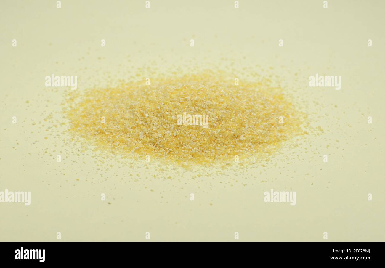 Polenta ou farine de maïs isolée sur fond blanc. Tas de semoule de maïs isolée sur fond blanc