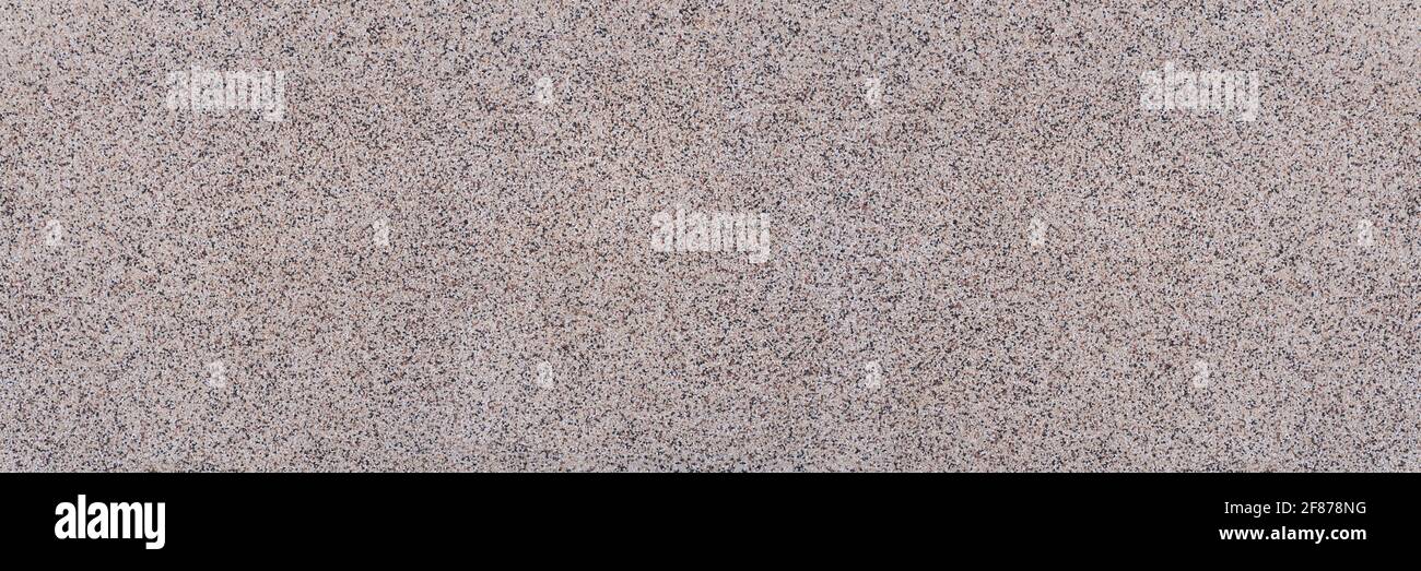 Gros plan panoramique d'une dalle avec texture granuleuse abstraite de petites pierres Banque D'Images