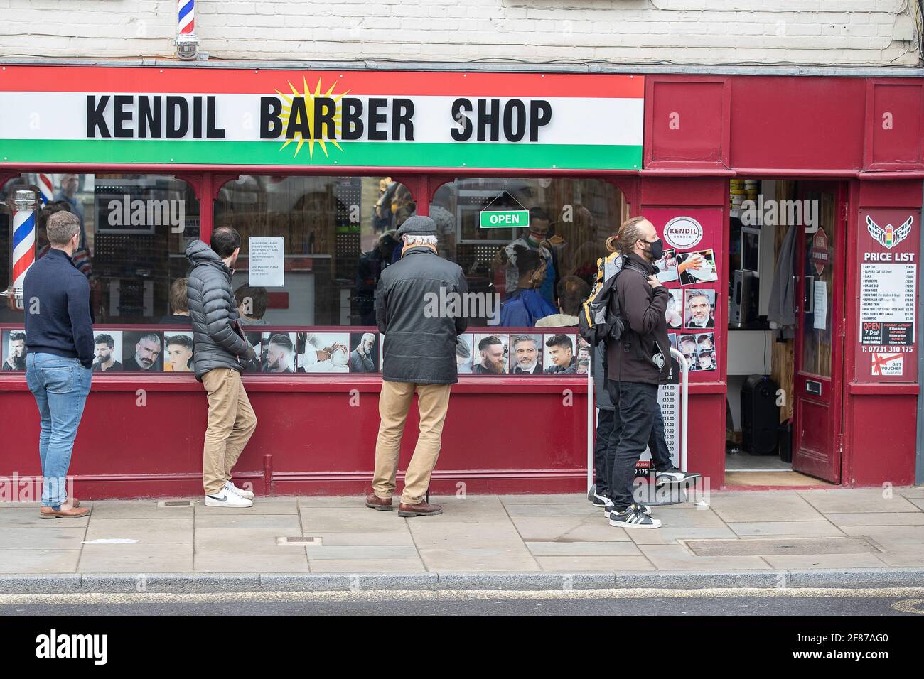 Chichester, Royaume-Uni. 12 avril 2021. Les hommes font la queue à l'extérieur d'un barbier, car la vente au détail n'est pas essentielle et d'autres entreprises rouvrent à mesure que les restrictions de verrouillage de l'Angleterre sont assouplies. Crédit : Paul Terry photo/Alamy Live News Banque D'Images