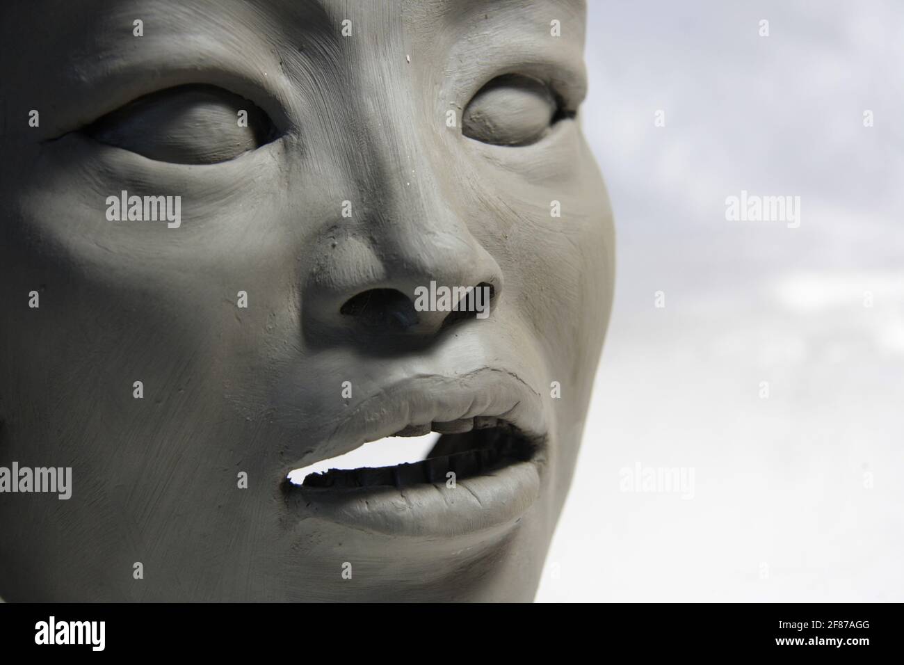 Visage asiatique féminin. Sculpture en argile humide. Yeux, nez, dents et  bouche orientaux. Détail de la statue sur fond blanc Photo Stock - Alamy