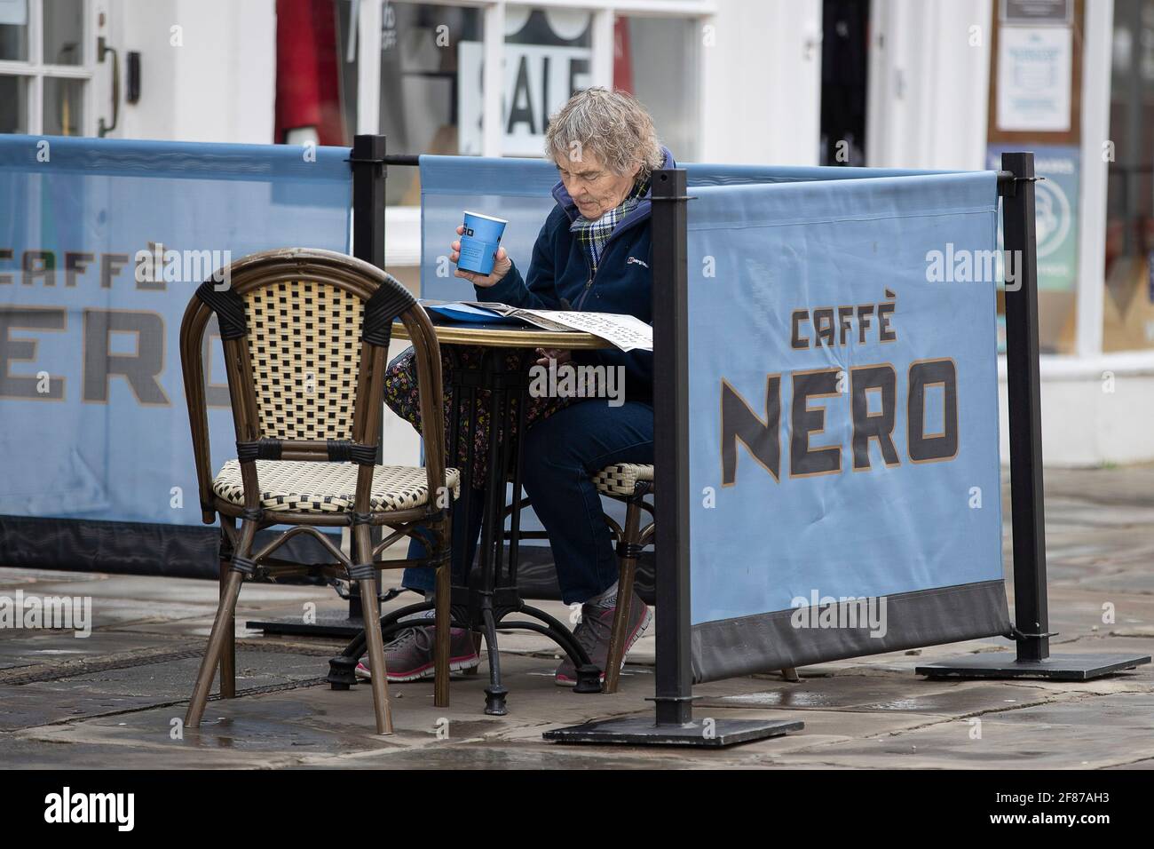 Chichester, Royaume-Uni. 12 avril 2021. Les membres du public peuvent profiter de rafraîchissements à l'extérieur de Caffe Nero en tant que magasin de détail non essentiel et d'autres entreprises rouvrent à mesure que les restrictions de verrouillage de l'Angleterre sont assouplies. Crédit : Paul Terry photo/Alamy Live News Banque D'Images