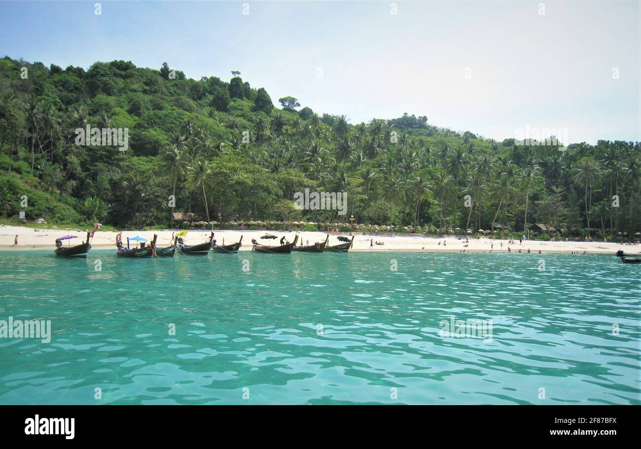 De beaux bateaux à longue queue dans les eaux bleues d'une baie de Phuket en Thaïlande prêts à aller avec les touristes. Banque D'Images