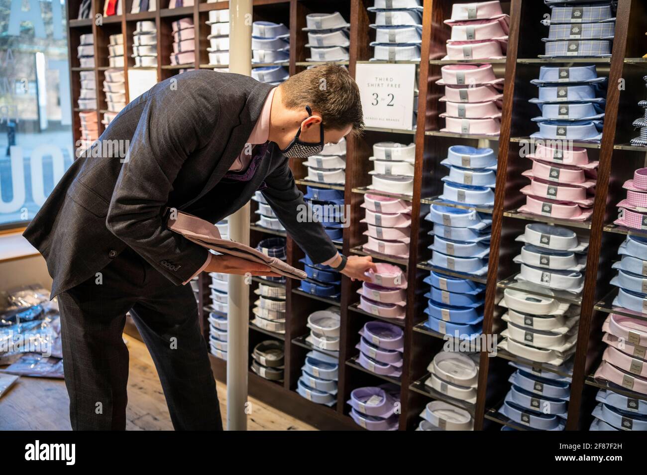 Cambridge, Royaume-Uni. 12 avril 2021. Le personnel attend ses premiers clients dans le magasin de vêtements Moss Bros alors que les boutiques rouvrent à Cambridge dans le cadre de l'assouplissement des restrictions de verrouillage de Covid 19 au Royaume-Uni. La succursale est fermée depuis près d'un an. La feuille de route permet aujourd'hui l'ouverture de magasins non essentiels dans toute l'Angleterre. C'était un début de journée relativement calme, car les acheteurs retournaient dans les magasins de détail de High Street. Crédit : Julian Eales/Alay Live News Banque D'Images