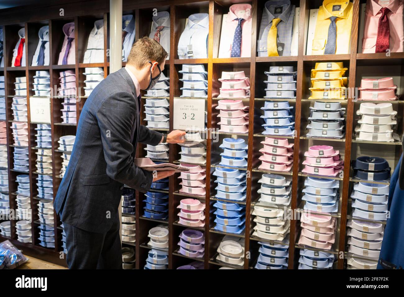 Cambridge, Royaume-Uni. 12 avril 2021. Le personnel attend ses premiers clients dans le magasin de vêtements Moss Bros alors que les boutiques rouvrent à Cambridge dans le cadre de l'assouplissement des restrictions de verrouillage de Covid 19 au Royaume-Uni. La succursale est fermée depuis près d'un an. La feuille de route permet aujourd'hui l'ouverture de magasins non essentiels dans toute l'Angleterre. C'était un début de journée relativement calme, car les acheteurs retournaient dans les magasins de détail de High Street. Crédit : Julian Eales/Alay Live News Banque D'Images