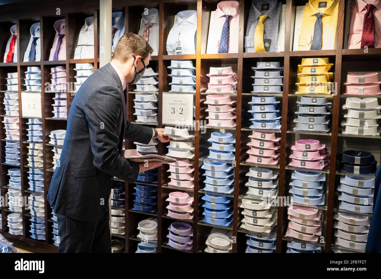 Cambridge, Royaume-Uni. 12 avril 2021. Le personnel attend ses premiers clients dans le magasin de vêtements Moss Bros alors que les boutiques rouvrent à Cambridge dans le cadre de l'assouplissement des restrictions de verrouillage de Covid 19 au Royaume-Uni. La succursale est fermée depuis près d'un an. La feuille de route permet aujourd'hui l'ouverture de magasins non essentiels dans toute l'Angleterre. C'était un début de journée relativement calme, car les acheteurs retournaient dans les magasins de détail de High Street. Crédit : Julian Eales/Alay Live News Banque D'Images