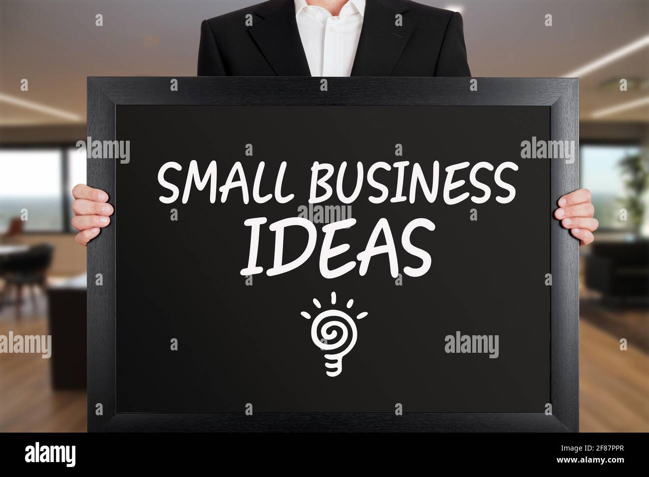 Homme d'affaires tient un grand panneau avec le message petites idées d'affaires avec l'icône d'ampoule. Concept d'idées créatives pour les petites entreprises. Banque D'Images