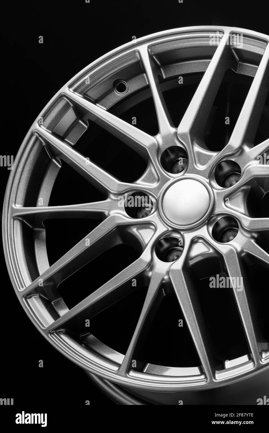 roues, rayons et jante en alliage légers et sportifs, gros plan sur fond noir, gros plan vertical. Banque D'Images