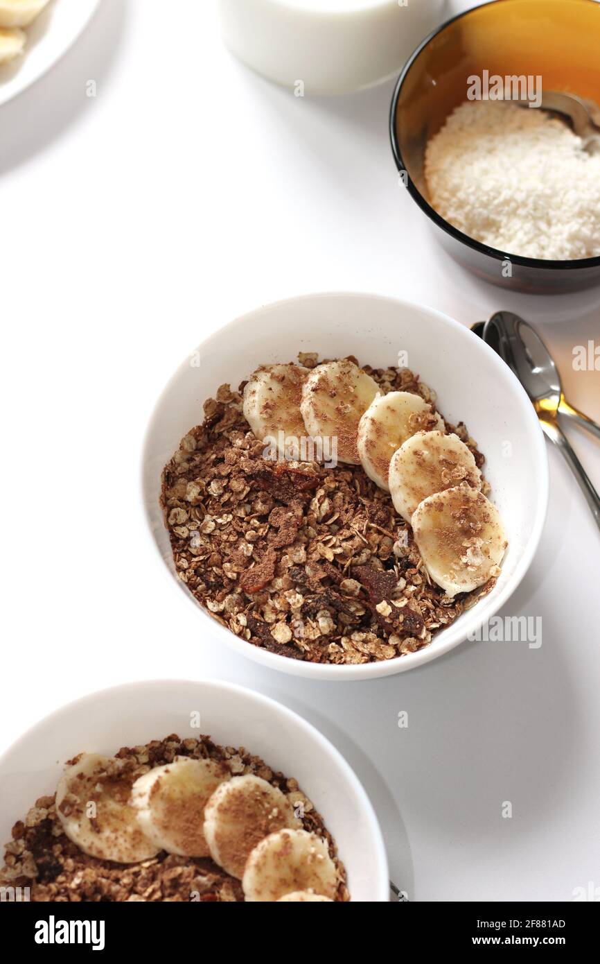 Petit-déjeuner. Bols de céréales à granola avec pot à lait et bol à flocons de noix de coco. Banque D'Images