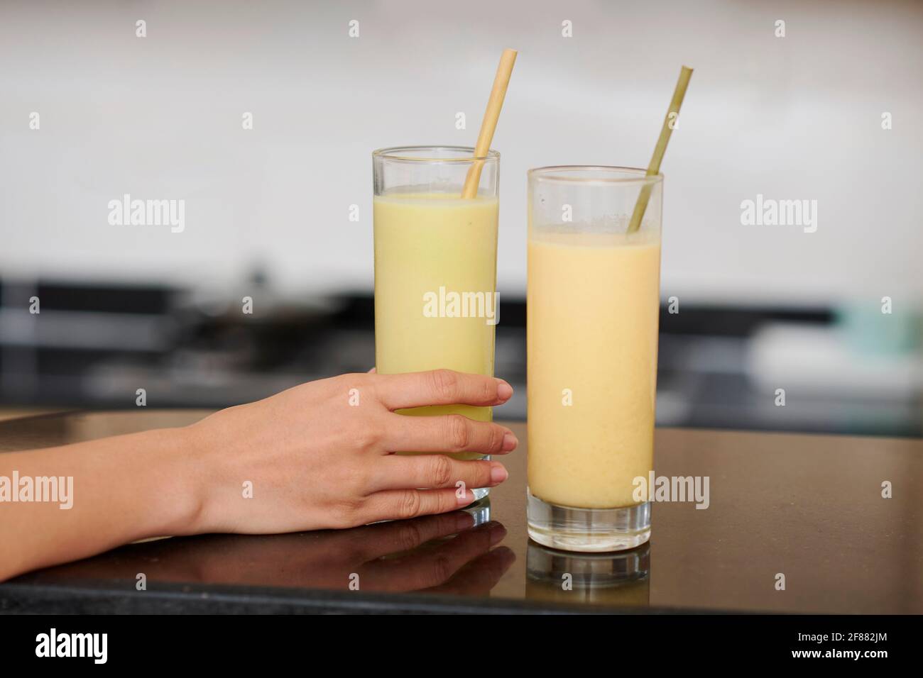 Image en gros plan d'une jeune femme parlant verre de fruit smoothie ou cocktail de protéines Banque D'Images