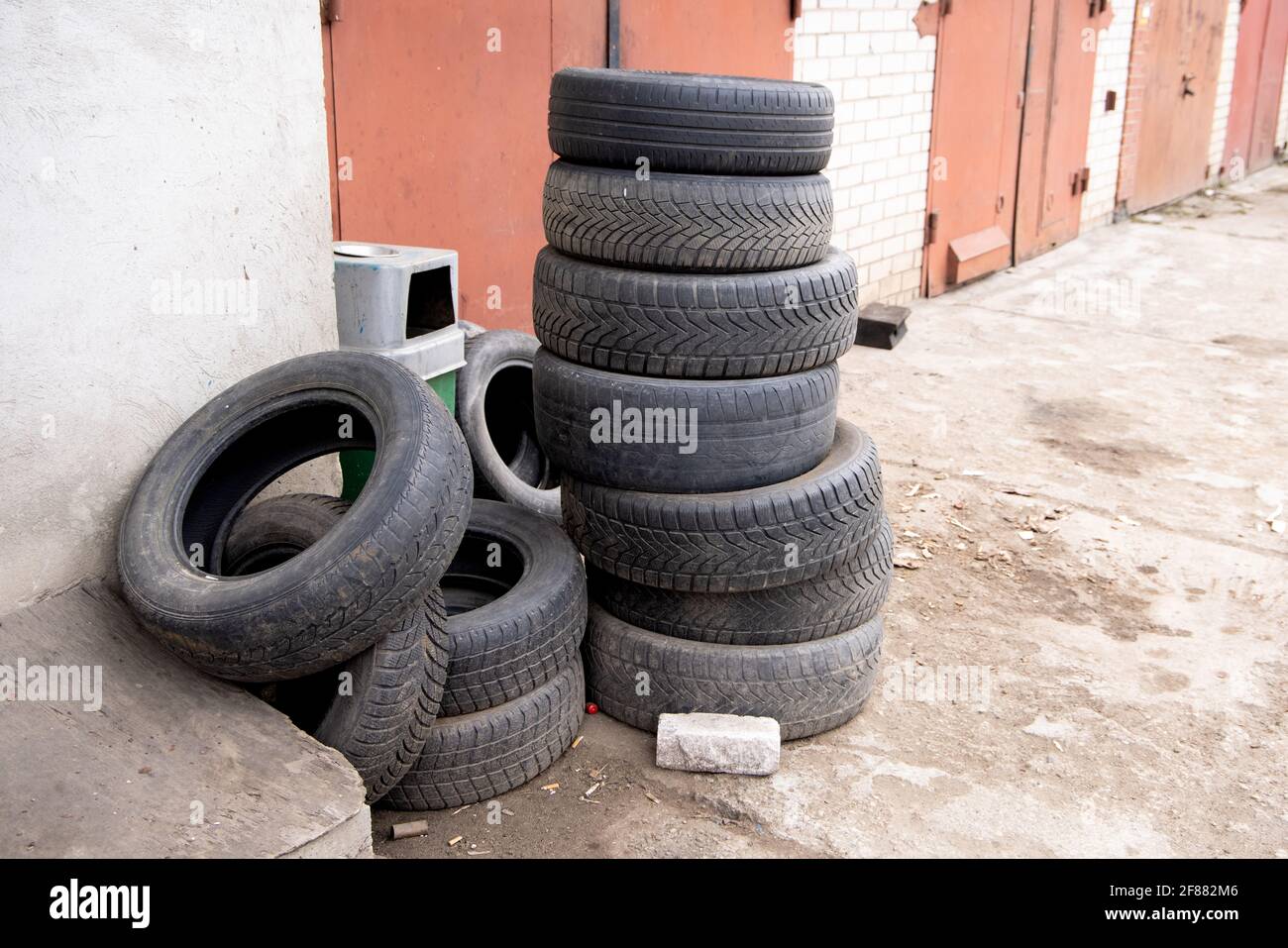 Pile de vieux pneus de voiture contre le mur de brique de service de pneus  ou de garage. Pollution, recyclage et réchauffement de la planète Photo  Stock - Alamy