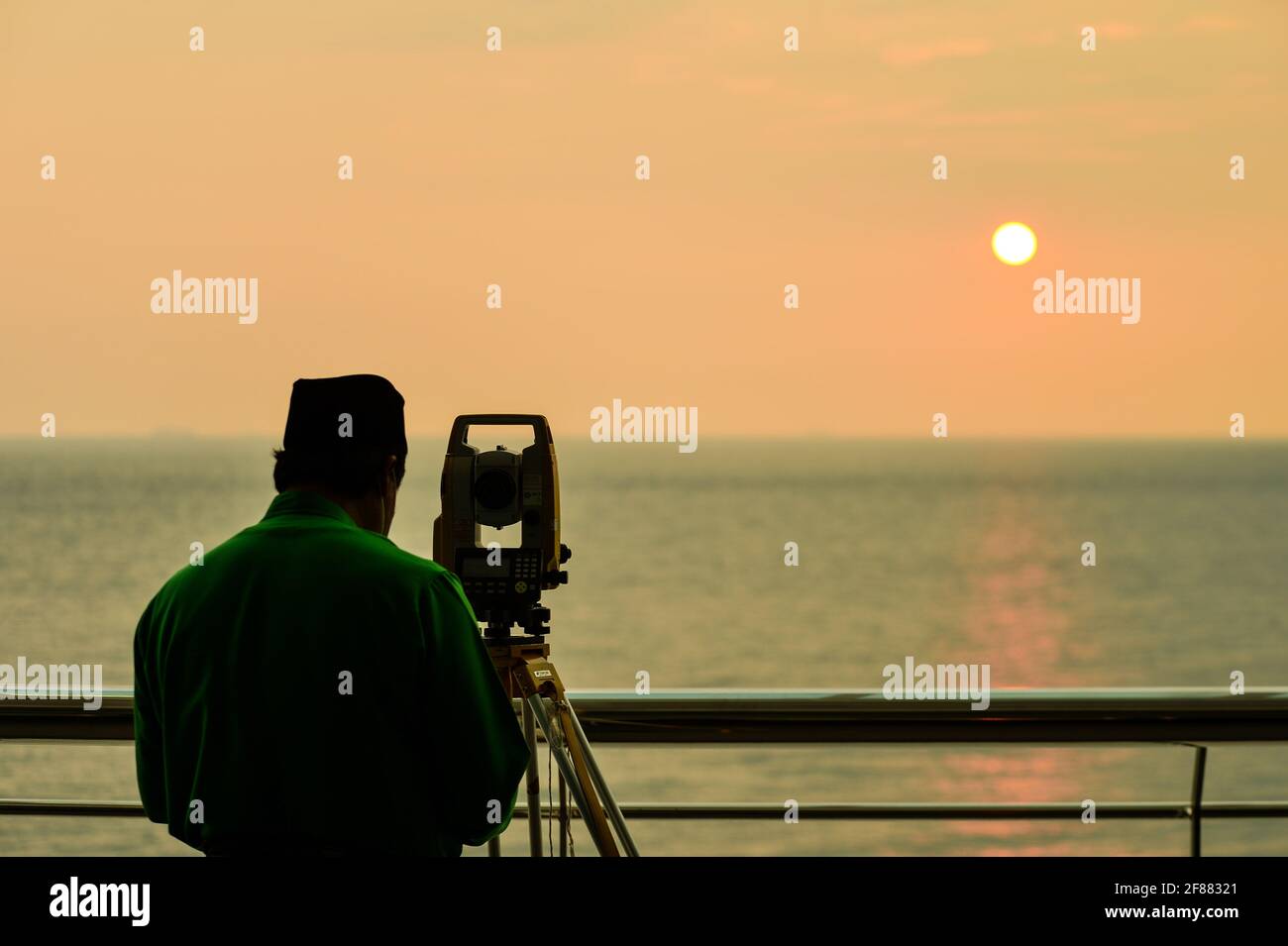 Port Dickson, Malaisie. 12 avril 2021 : des officiers religieux islamiques observant l'observation de la nouvelle lune à l'aide d'une théodolite à l'Observatoire Teluk Kemang de Port Dickson, en Malaisie, pour signifier le début du mois de jeûne de Ramadan. Les musulmans du monde entier célèbrent le mois Saint en s'abstenant de manger et de boire du lever au coucher du soleil. Credit: Fuad Nizam/ZUMA Wire/Alay Live News Banque D'Images