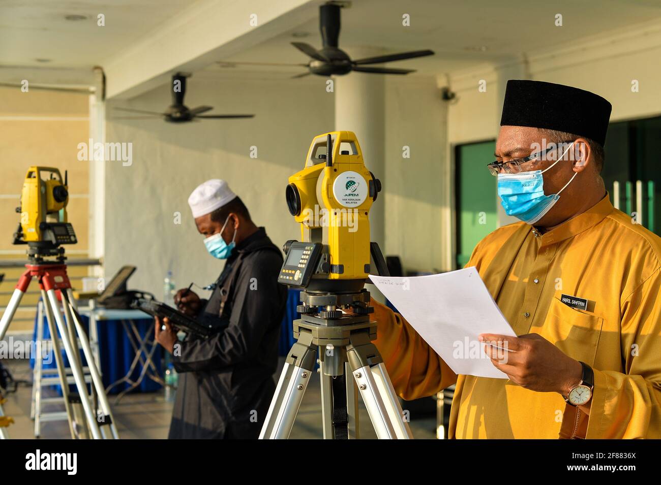 Port Dickson, Malaisie. 12 avril 2021 : des officiers religieux islamiques observant l'observation de la nouvelle lune à l'aide d'une théodolite à l'Observatoire Teluk Kemang de Port Dickson, en Malaisie, pour signifier le début du mois de jeûne de Ramadan. Les musulmans du monde entier célèbrent le mois Saint en s'abstenant de manger et de boire du lever au coucher du soleil. Credit: Fuad Nizam/ZUMA Wire/Alay Live News Banque D'Images