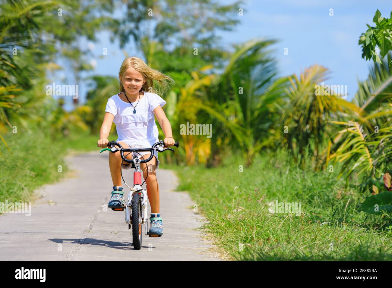 Randonnée à vélo. Jeune cycliste enfant à vélo. Un enfant heureux s'amuse sur le sentier. Vie familiale active, sports, activités de plein air Banque D'Images