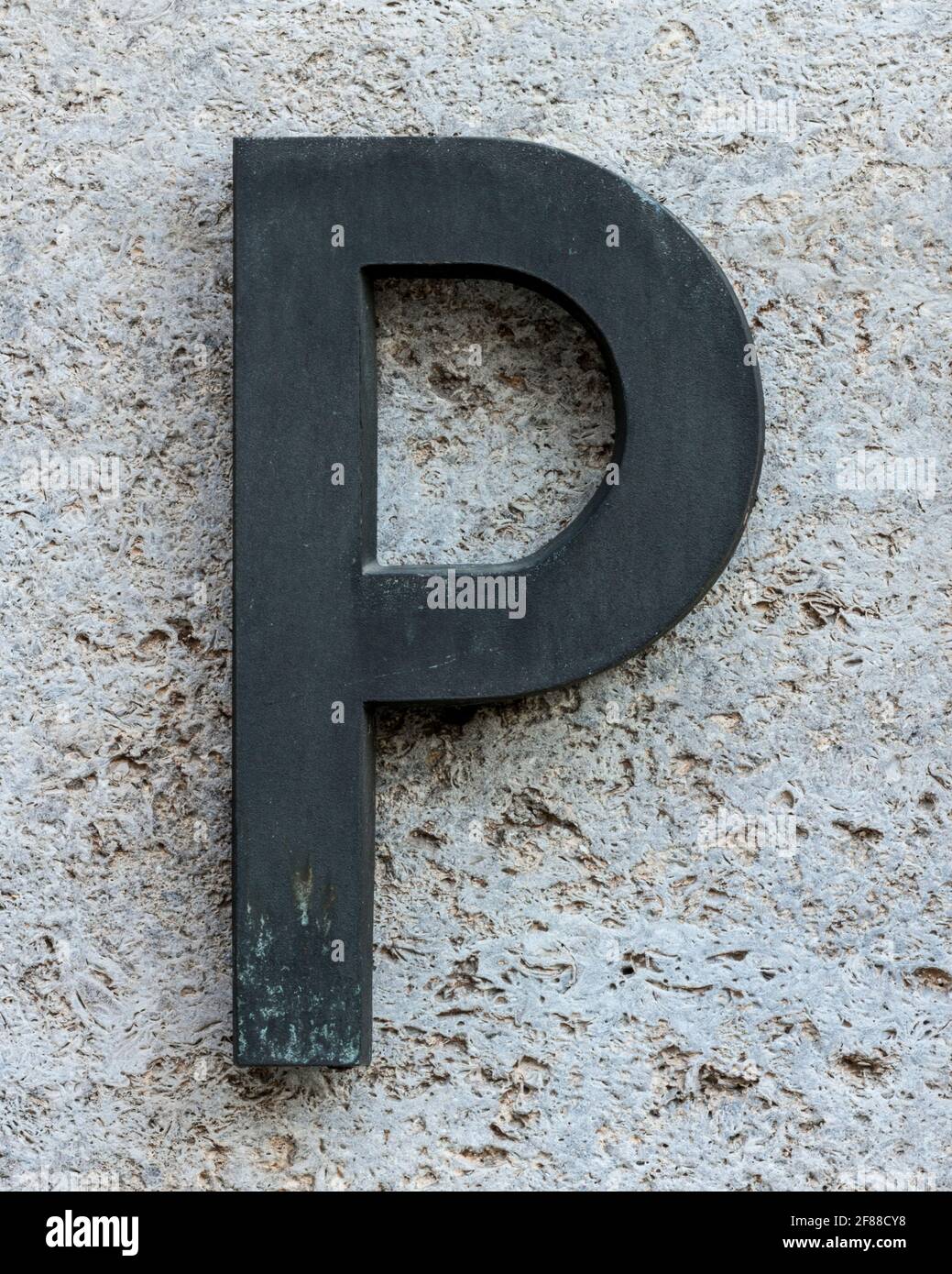 Lettre P en métal sur un mur en pierre Banque D'Images