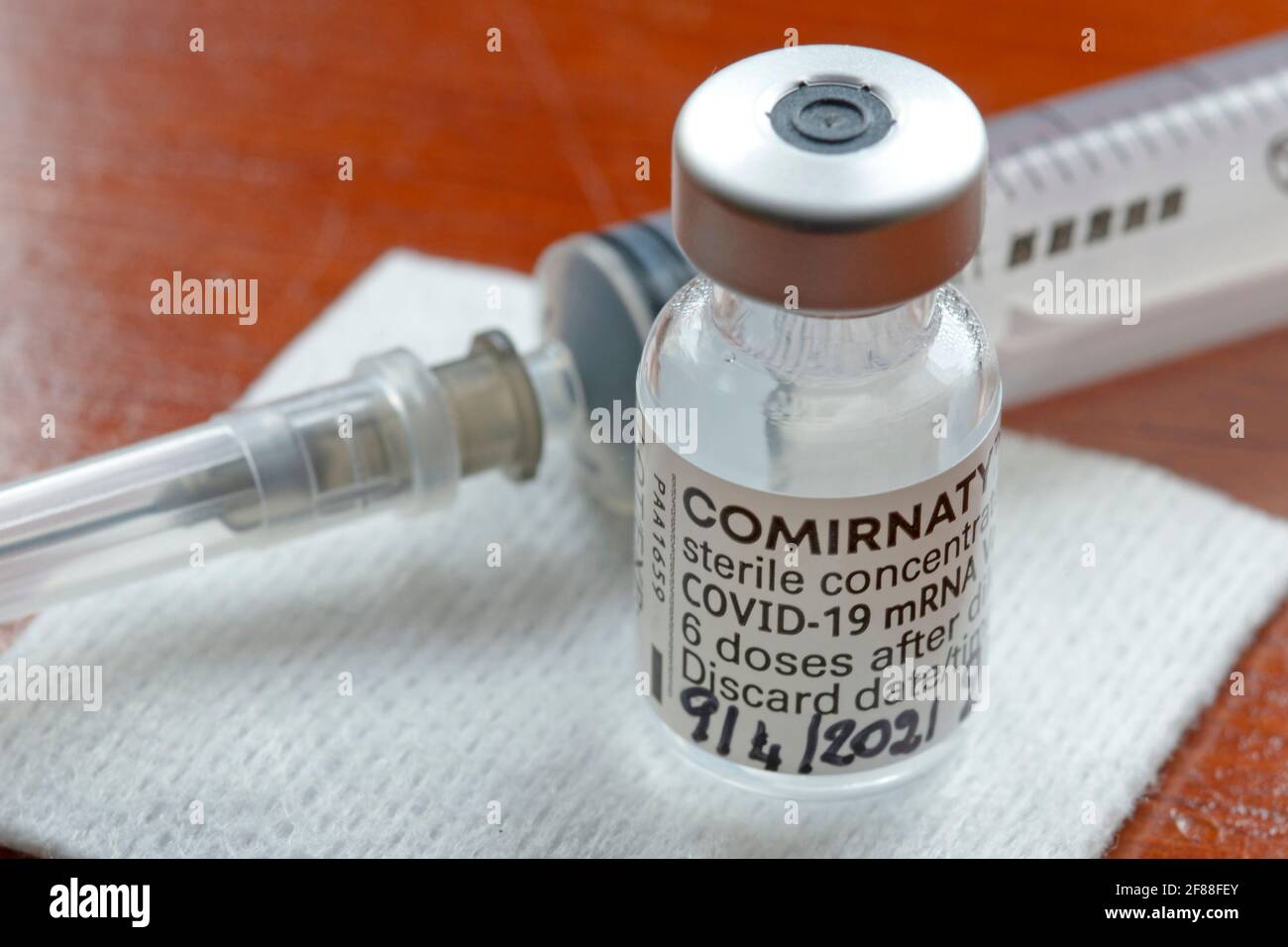 Gênes, Italie -avril 2021, Comirnaty, vaccin ARN contre le covid-19, développé par Pfizer BioNTech sur fond rouge Banque D'Images