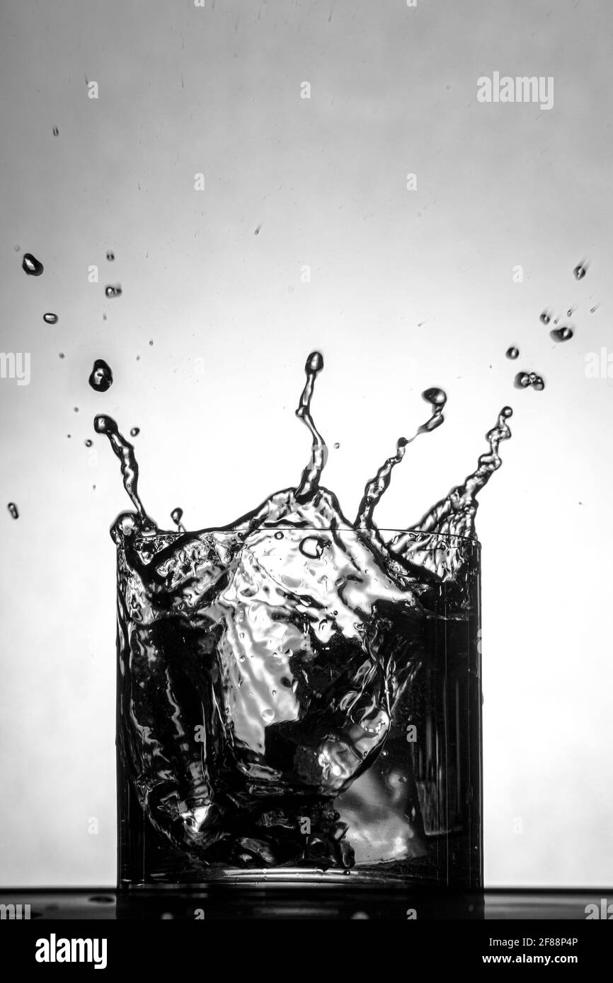 De l'eau éclabousse le verre à whisky Banque D'Images