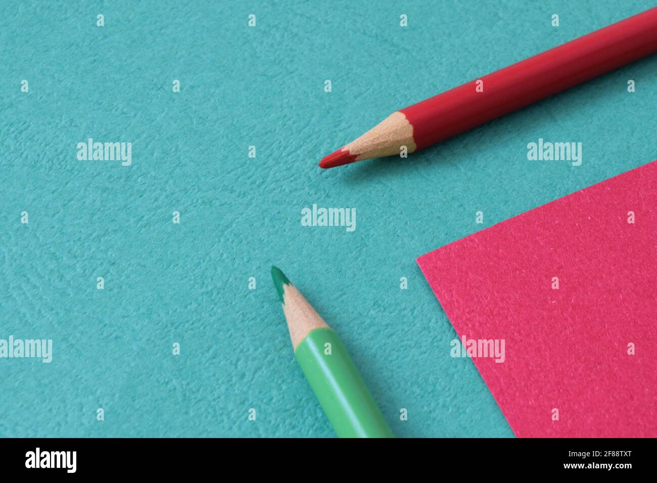 Retour à l'école. Les crayons verts et rouges sont situés sur un arrièreplan coloré. Concept