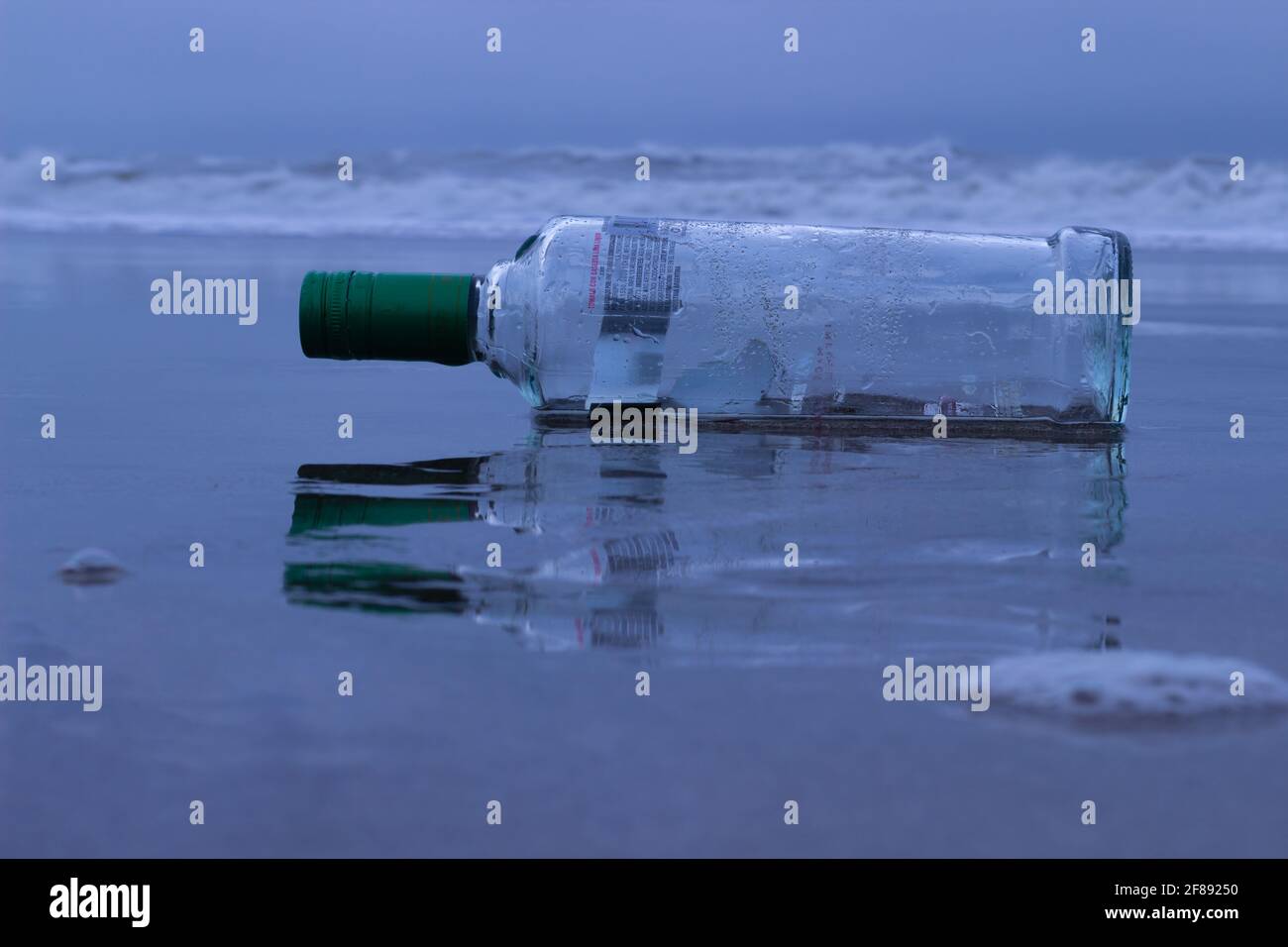 Bouteille de verre dans le sable. Banque D'Images