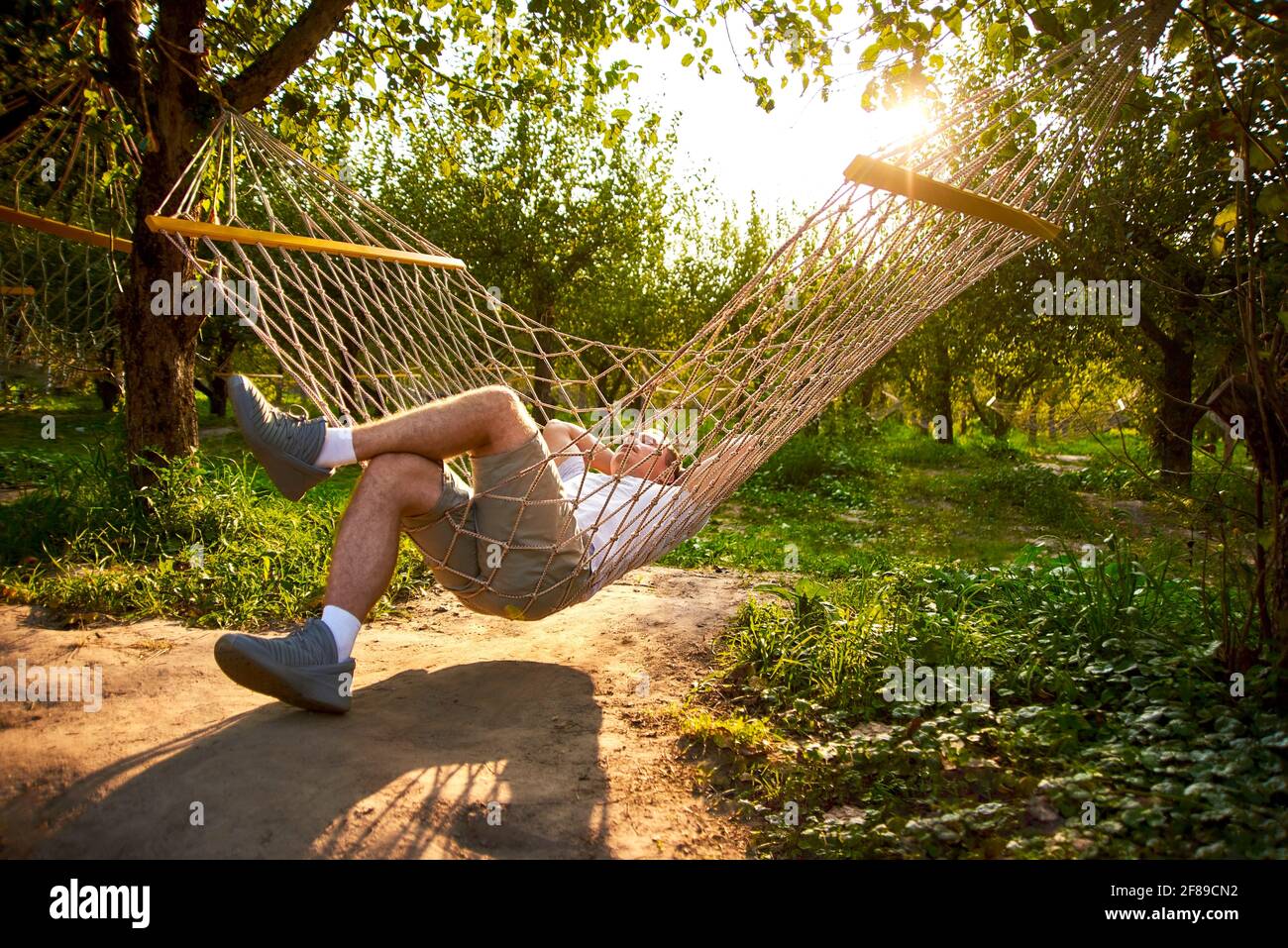 l'homme se rafraîchissez dans un hamac dans la forêt par beau temps.  concept de repos dans le jardin Photo Stock - Alamy