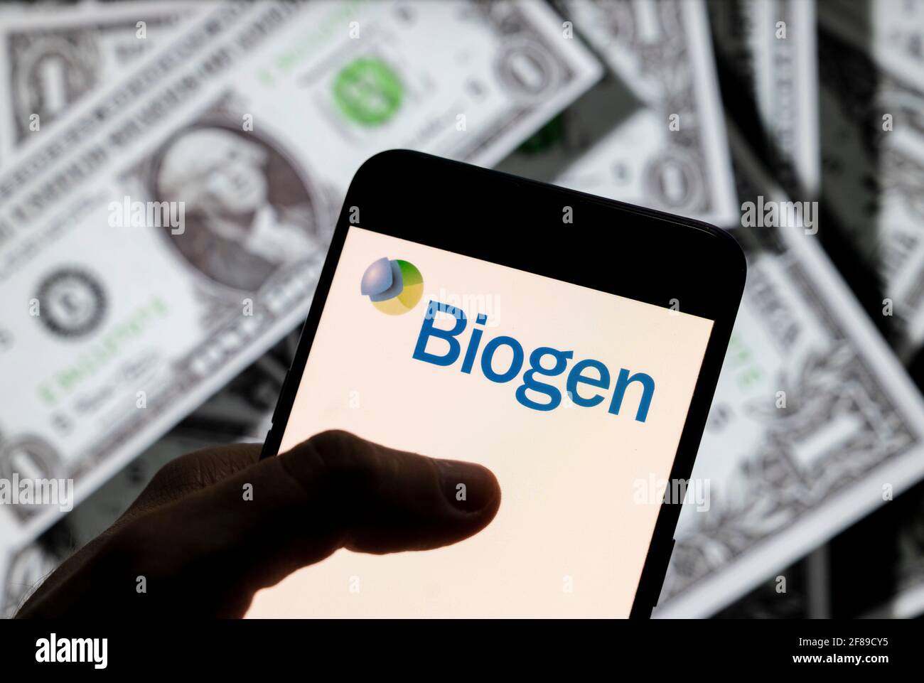 Dans cette illustration de photo, le logo de la multinationale américaine Biogen, vu sur un écran d'appareil mobile Android avec la devise de l'icône dollar des États-Unis, symbole d'icône $ en arrière-plan. Banque D'Images