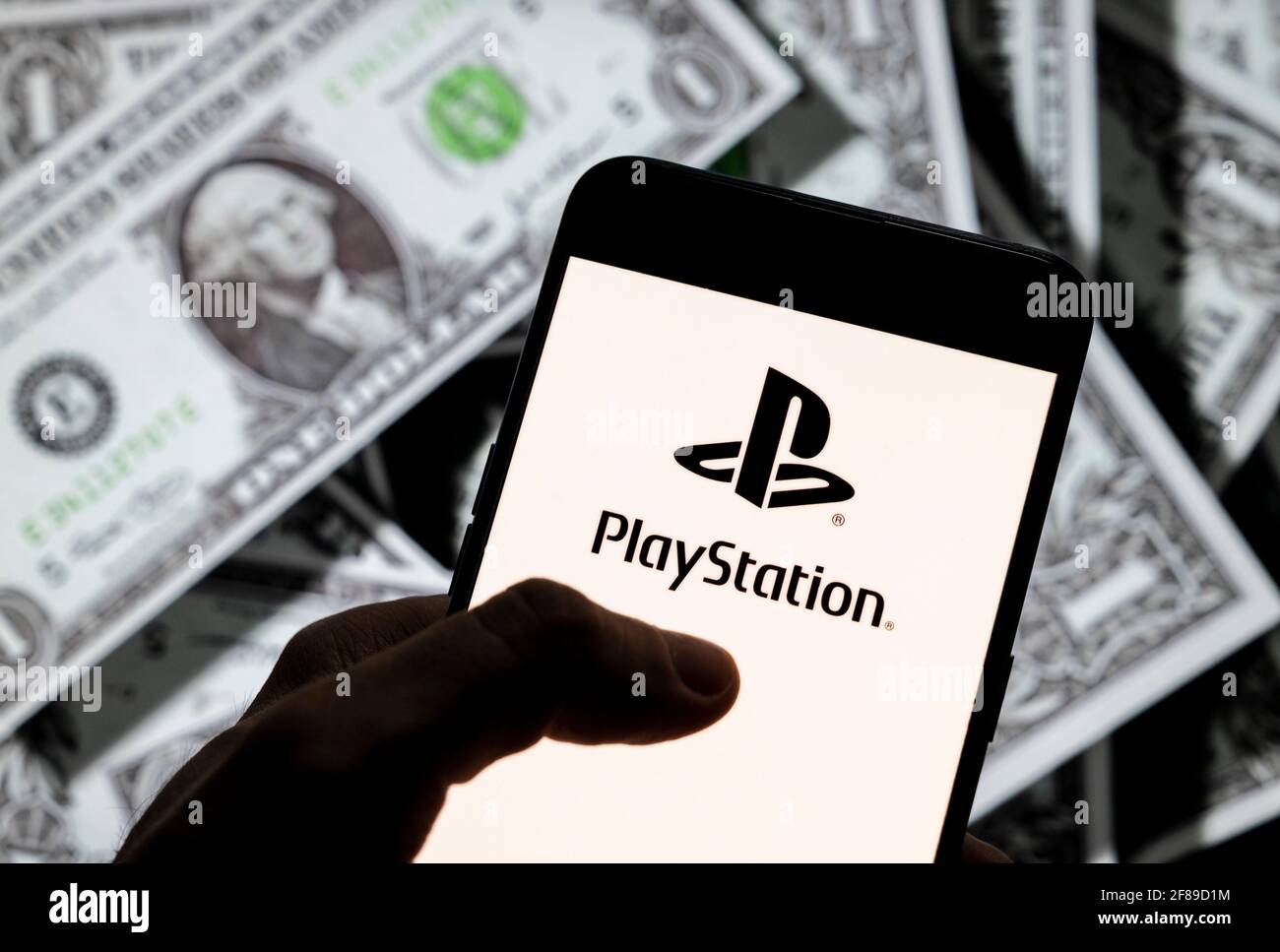 Dans cette illustration, la marque japonaise de jeux vidéo créée et détenue par Sony Computer Entertainment, PlayStation, logo est visible sur un écran d'appareil mobile Android avec la devise de l'icône dollar des États-Unis, symbole d'icône $ en arrière-plan. Banque D'Images