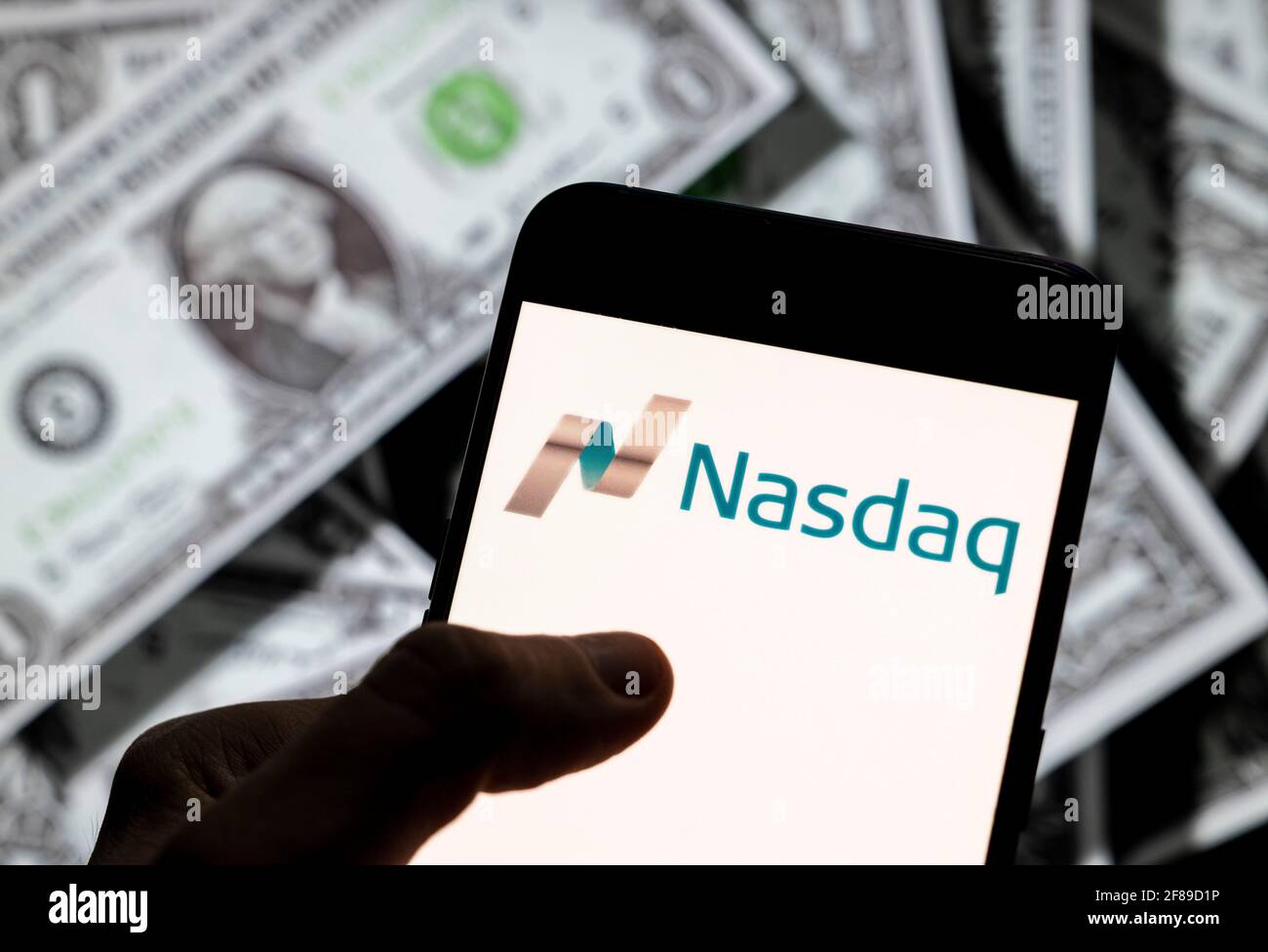 Dans cette illustration, l'indice de la bourse américaine, le logo Nasdaq vu sur un écran d'appareil mobile Android avec la devise de l'icône dollar des États-Unis, symbole de l'icône $ en arrière-plan. Banque D'Images