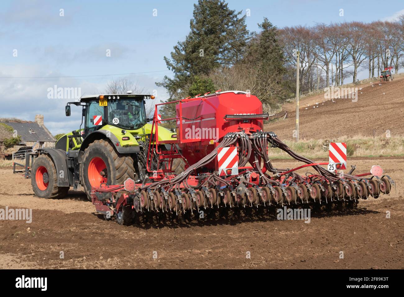 Vue arrière d'un semoir Horsch Pronto Tiré par un tracteur Claas Axion 940 sur un Soleil Printemps après-midi Banque D'Images