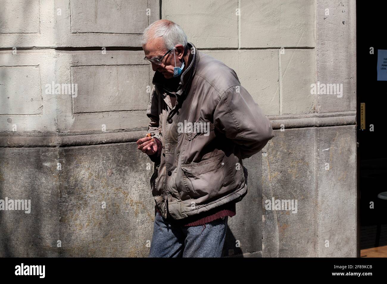 Homme mentalement malade fumant une cigarette dans la rue. Banque D'Images