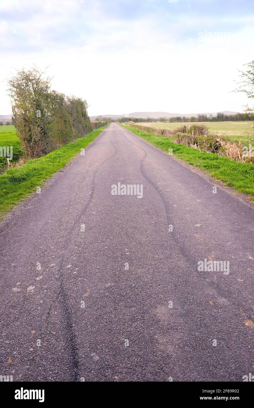 Avril 2021 - des marques de protection sont laissées sur une route rurale droite à Somerset, au Royaume-Uni. Banque D'Images