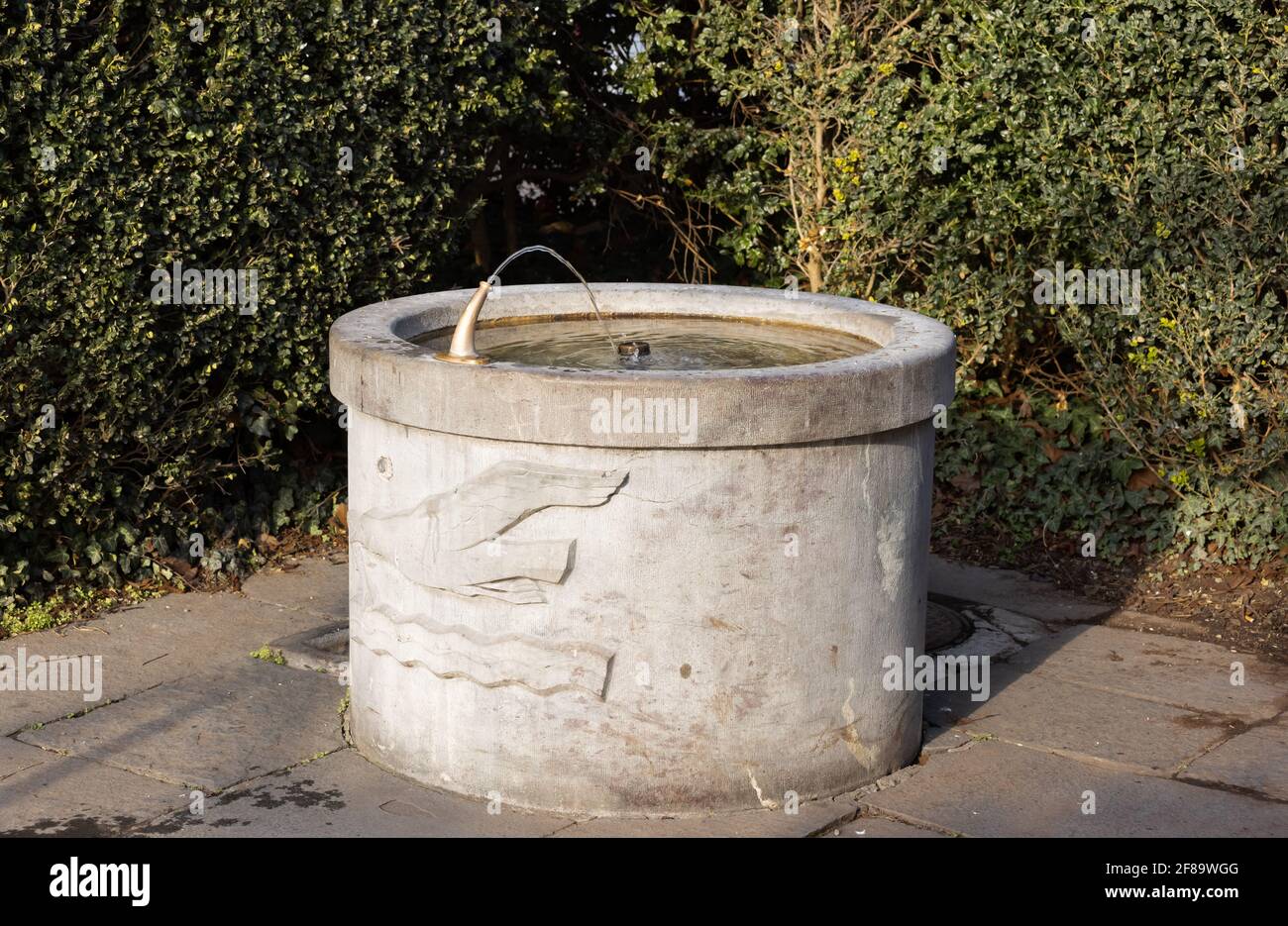 fontaine ronde en pierre brune avec mouette gravée et eau ondulée, le robinet d'eau est en service, de jour en jour, sans personne Banque D'Images