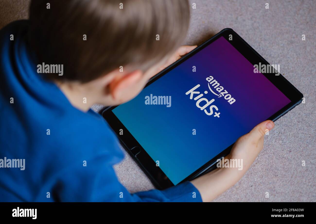 Le logo de l'application Amazon Kids + vu sur l'écran de l'ipad tient dans les mains des jeunes enfants. Concept pour l'application de divertissement pour enfants d'Amazon. Stafford, Royaume-Uni, A Banque D'Images