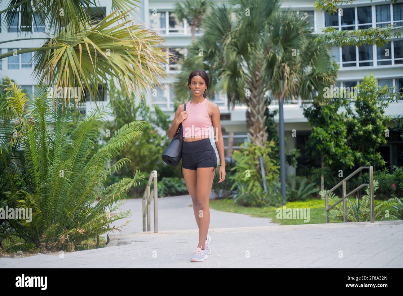 Portrait d'une jeune femme afro-américaine en marchant avec tapis de yoga Banque D'Images