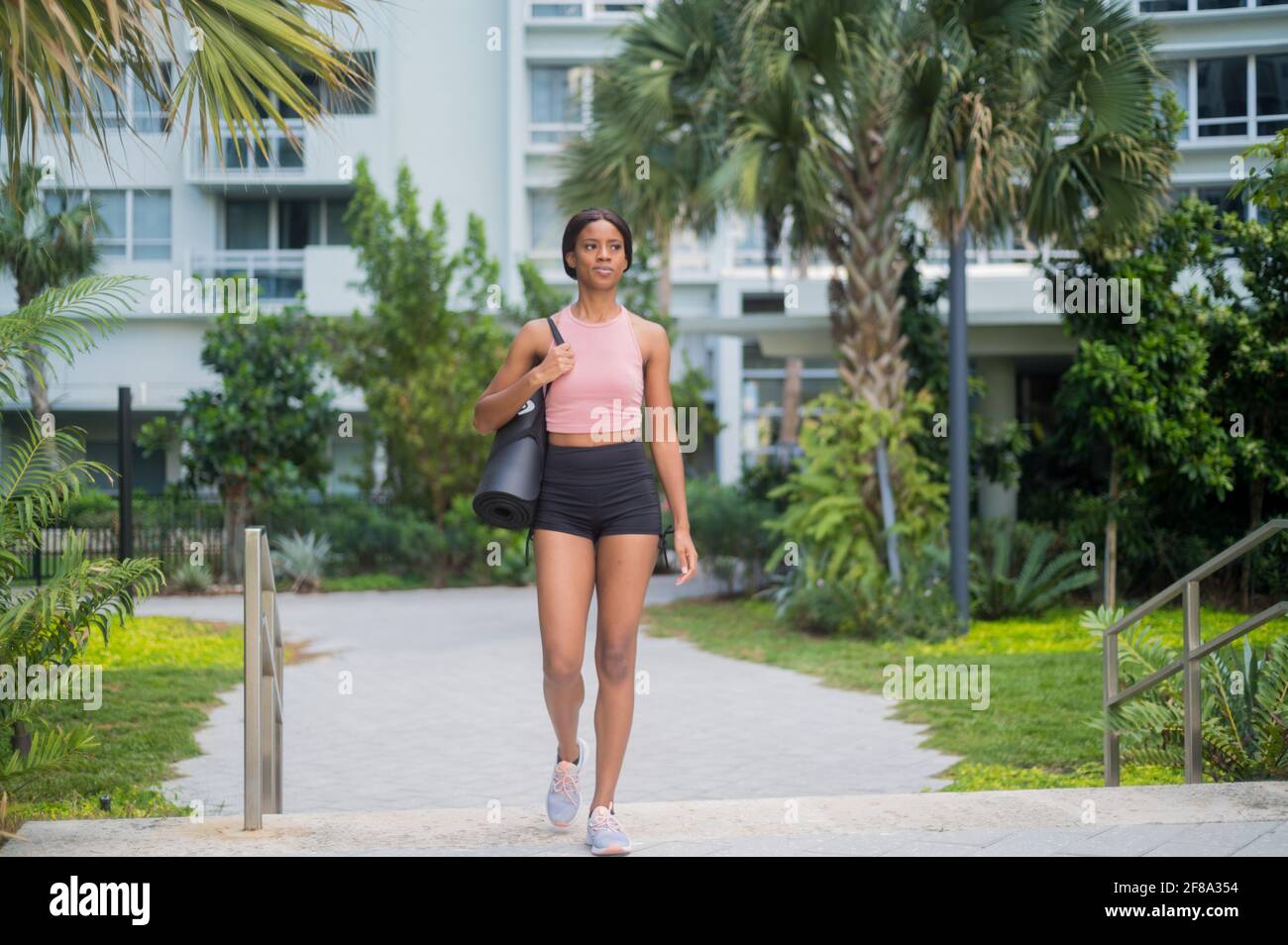 Portrait d'une jeune femme afro-américaine en marchant avec tapis de yoga Banque D'Images