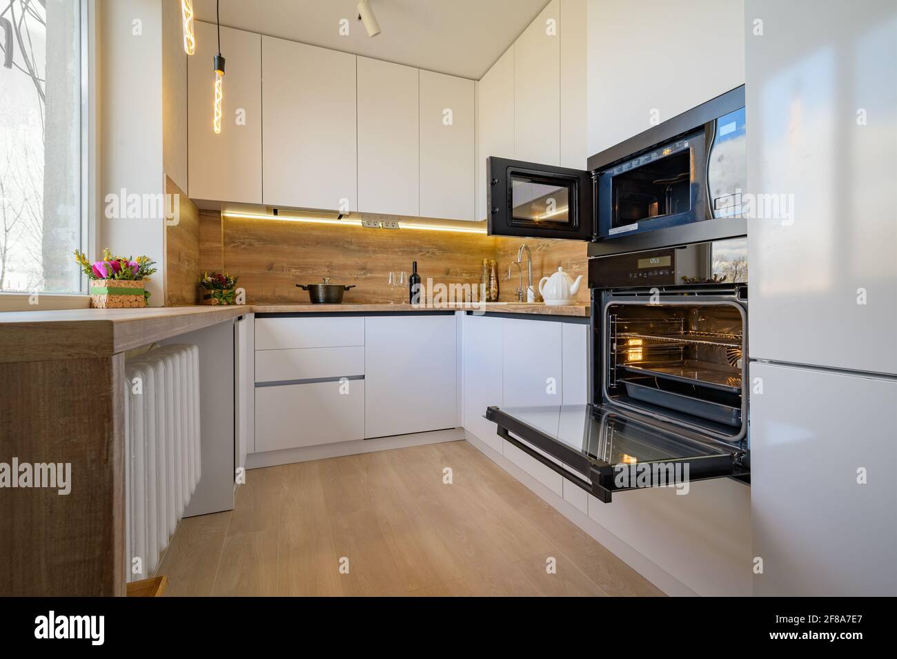 Cuisine moderne en bois blanc et beige avec four ouvert Banque D'Images