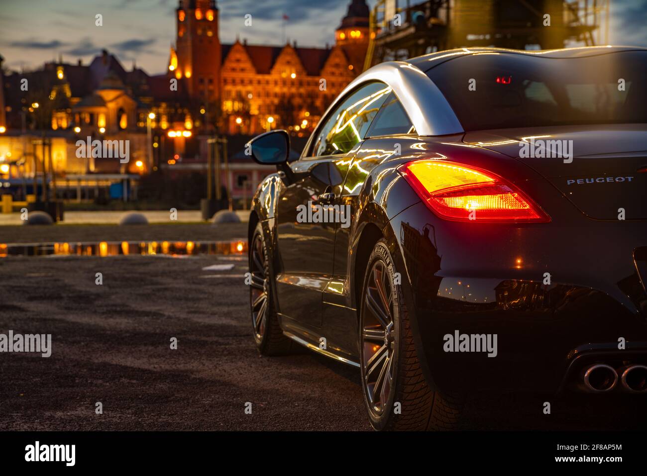 Magnifique Peugeot RCZ coupé illuminé par la lumière du port grues Banque D'Images