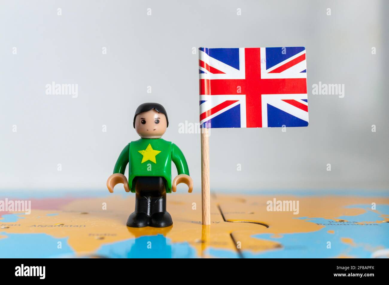 POZNAN, POLOGNE - 06 avril 2021 : figurine jouet joutive située à côté d'un drapeau national britannique. Banque D'Images