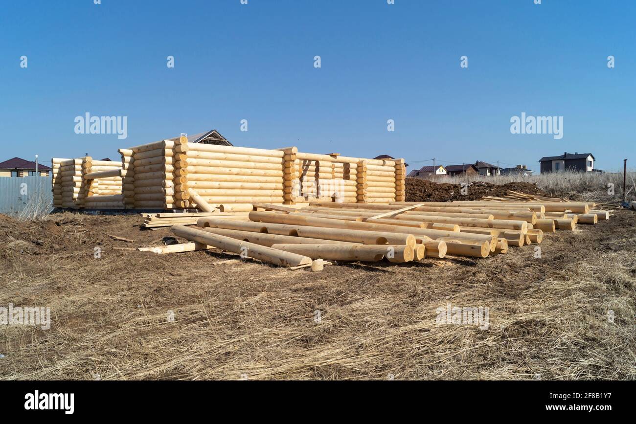 Construction d'une maison en bois par jour ensoleillé au printemps. Nouvelle maison en rondins contre le ciel bleu Banque D'Images