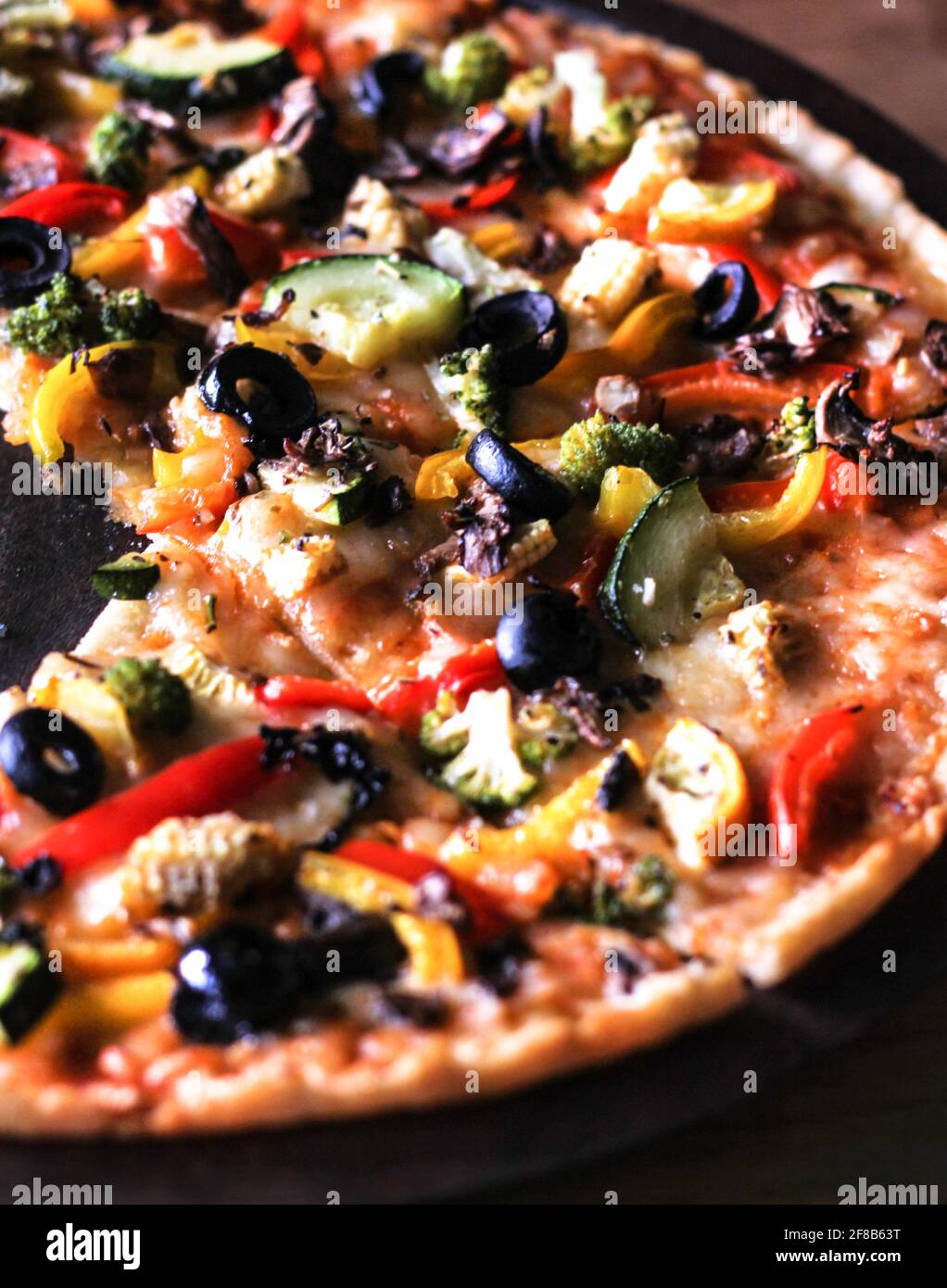 La pizza est un plat savoureux d'origine italienne composé d'une base aplatie habituellement ronde de pâte à base de blé levain, recouverte de tomates et de fromage. Banque D'Images