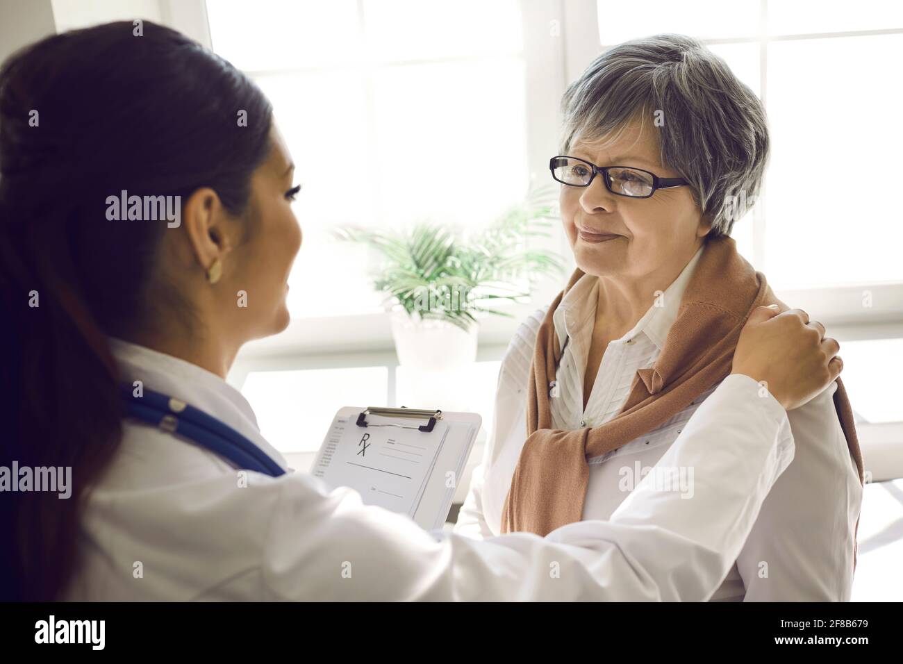 Souriante infirmière jeune femme médecin aide femme patiente senior gros plan Banque D'Images