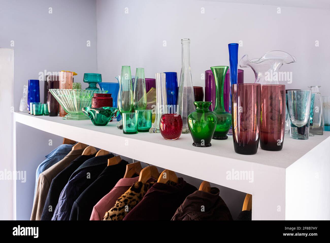 Collection de verre sur étagère au-dessus des manteaux, un bijou-comme l'étalage. Banque D'Images