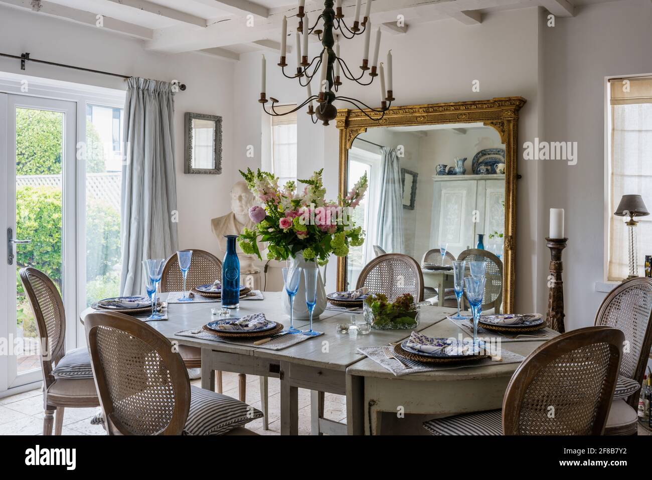 Miroir à cadre doré géorgien avec verrerie sur table à manger dans les années 1930, rénovation côtière dans l'ouest du Sussex. Banque D'Images