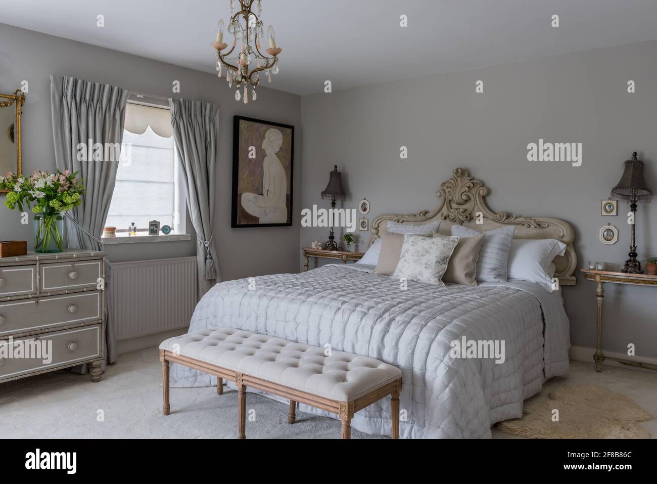 Tête de lit en mousseline avec murs dans la salle des lampes grise dans la chambre côtière du West Sussex. Banque D'Images