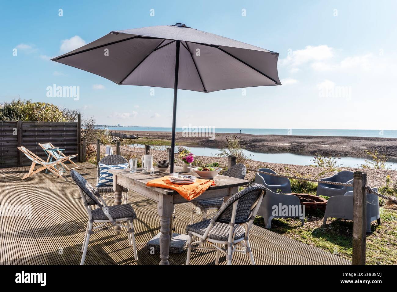 Paarasol ombre table et chaises sur la terrasse de West Sussex maison de vacances. Banque D'Images