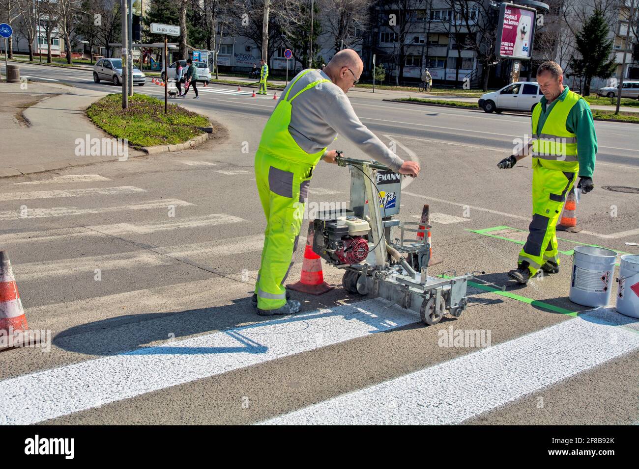 Zrenjanin, Serbie le 26 mars 2021. Les travailleurs d'une entreprise qui peint des passages piétons, communément appelés « zèbres », marquent et peignent sur l'asphalte. Banque D'Images