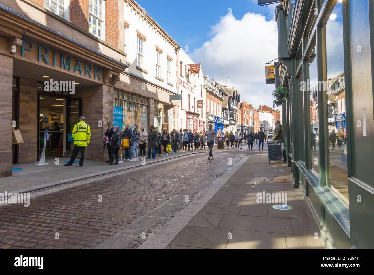 Le jour où les restrictions Covid 19 sont assouplies, les foules affluent vers les magasins avec des files d'attente à l'extérieur de Primark, Hereford UK. Avril 2021, Banque D'Images