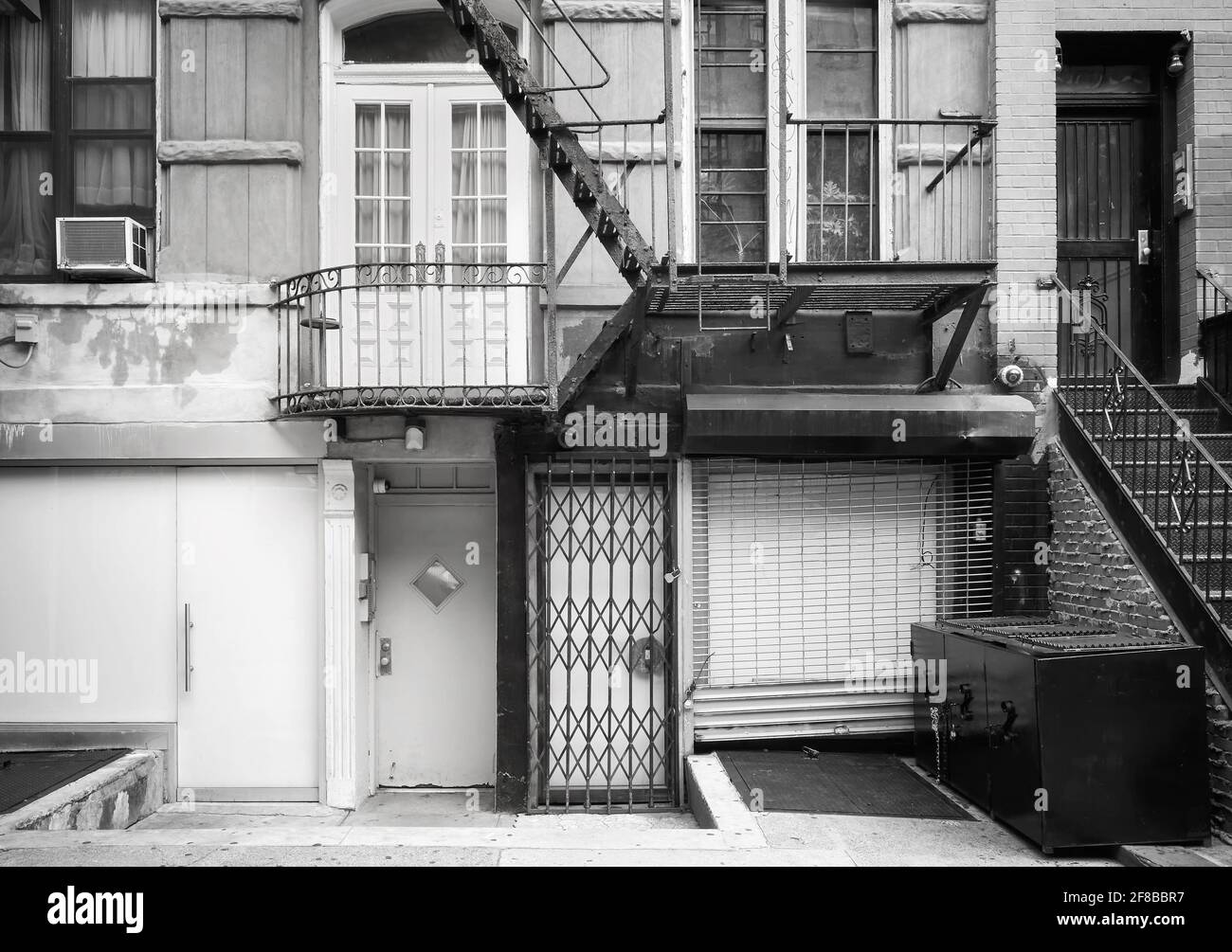 Photo en noir et blanc de la façade de l'ancien bâtiment avec évacuation au feu de fer, New York City, Etats-Unis. Banque D'Images