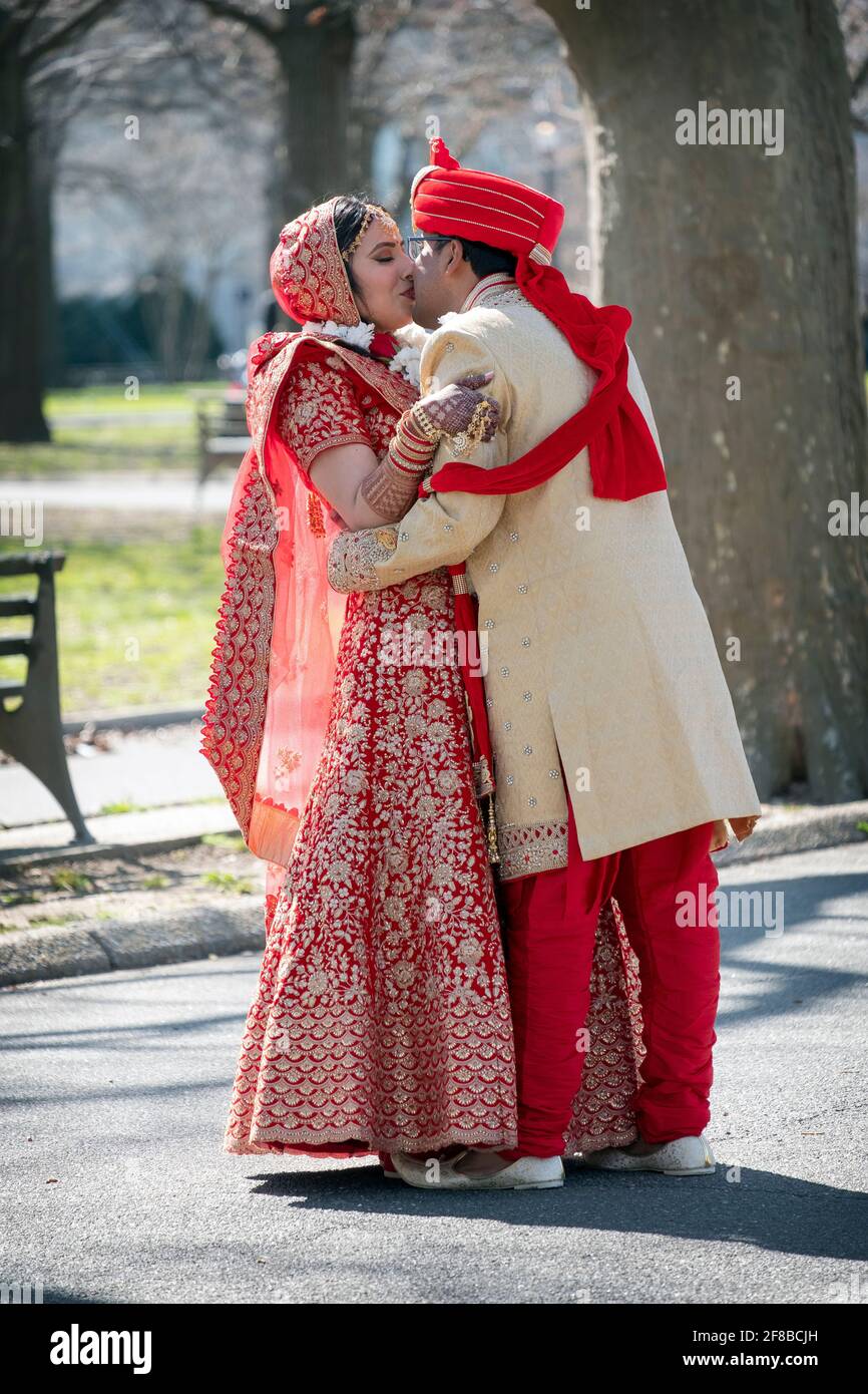 Un couple hindou en vêtements ethniques très ornés pose pour des photos avant mariage dans un parc à Queens, New York. Banque D'Images