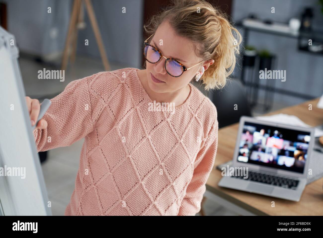 Une enseignante écrivant sur le tableau noir tout en enseignant à la maison Banque D'Images