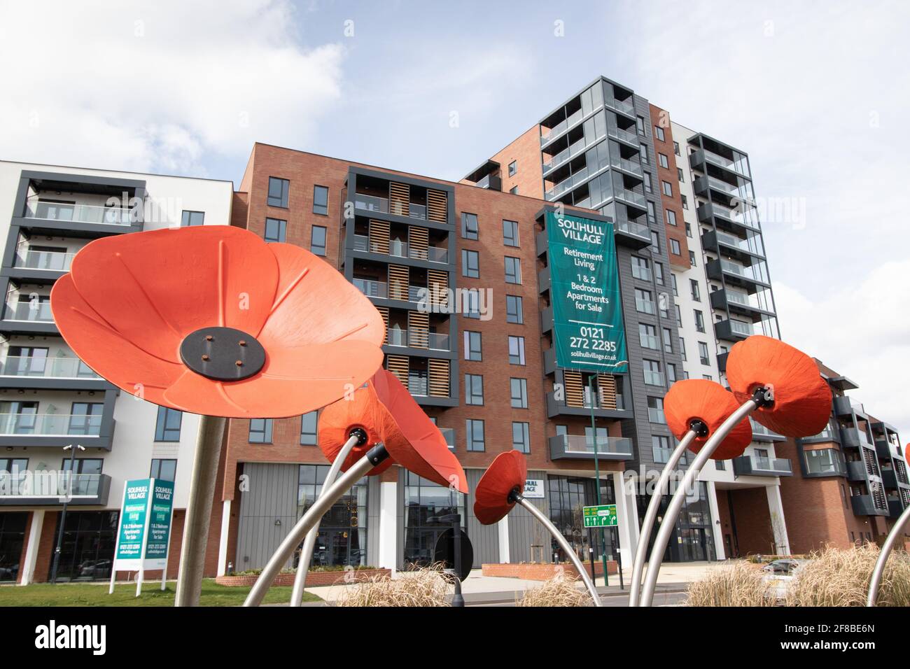 Sculptures géantes de pavot sur l'île de trafic en face de la Solihull village Extracare appartements Banque D'Images