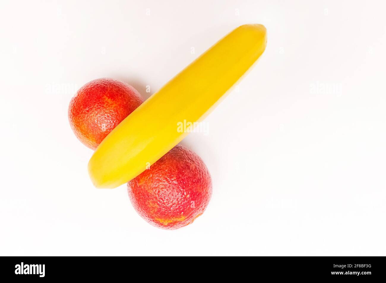 Drôle de concept de fruit, banane et deux oranges rouges isolées sur fond blanc. Banque D'Images Drôle de concept de fruit, banane et deux oranges rouges isolées sur fond blanc. Banque D'Images